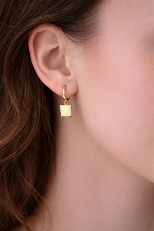 gold earrings, enamel earrings, hooped earrings, gold huggie earrings, yellow enamel earrings, woman wearing yellow gold square enamel earrings.