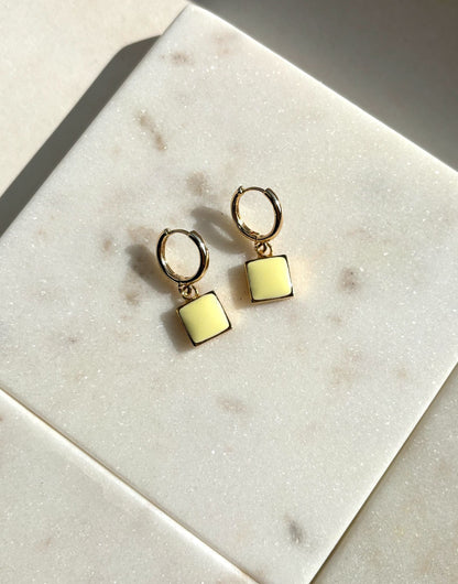 gold earrings, enamel earrings, hooped earrings, gold huggie earrings, yellow enamel earrings, woman wearing yellow gold square enamel earrings.